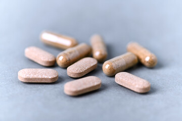 Ashwagandha (Withania somnifera) tablets and capsules on paper background. Close up. 