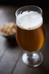 Glass of beer on dark wooden background.	