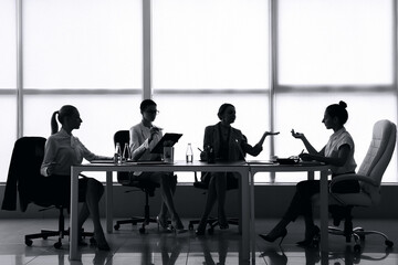 Silhouettes of businesswomen working in office
