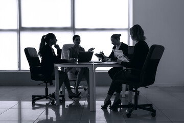 Silhouettes of businesswomen working in office