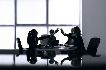 Silhouettes of businesswomen working in office
