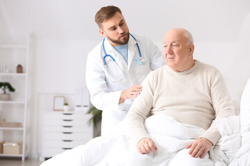 Fototapeta premium Doctor and senior man undergoing course of chemotherapy in clinic. Prostate cancer awareness concept