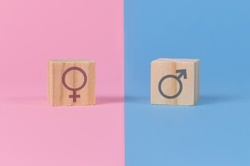 Gender stereotypes showing cubes with male and female signs on pink and blue backgroun