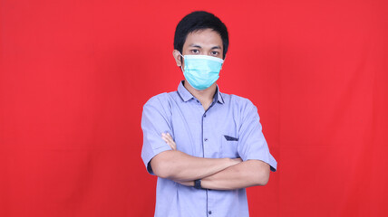 Asian man wearing mask isolated red background