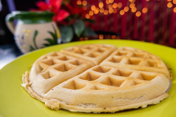 Round waffle on a yellow plate with Mexican clay cup as background