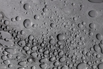 Fluid art moon texture. Abstract background with swirling paint effect. Liquid acrylic artwork with flowing bubbles. Mixed paints for background or poster. Black, white and gray overflowing colors