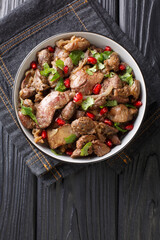 Delicious Kuchmachi made from chicken offal with spices, onions and pomegranate close-up in a bowl on the table. vertical top view from above