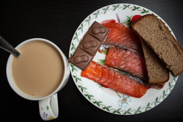 plate of grilled salmon steak with vegetables on wooden table, top view