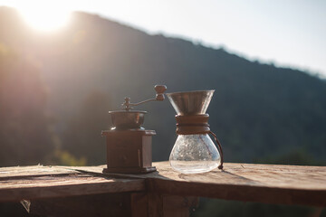 Hot arabica coffee and Vintage coffee drip equipment on wooden table in the morning with mountain...