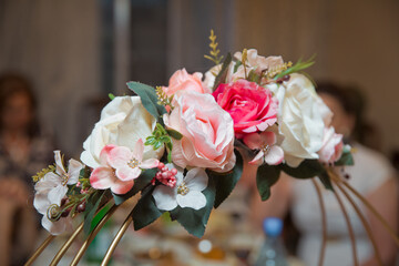 Engagement flowers basket . The handle of the engagement basket . There are candies in the basket decoration . Artificial flowers . Colorful flowers in a basket .