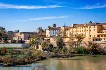 Fototapeta premium The Alcazar de los Reyes Cristianos (aka Alcazar of Cordoba) and the medieval mill on the bank of the river Guadaquivir in Cordoba, Andalusia, Spain. Photo taken from the Roman Bridge.
