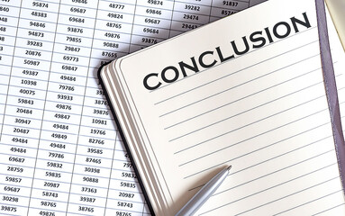 Fototapeta premium Business concept, on the table a notepad with the text of the CONCLUSION