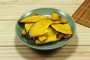 Roasted sliced fresh pumpkin on the plate. Famous vegetarian snack for diet. High fiber and nutrition food. 