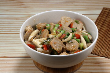 Fried and stirred spicy cutting shrimp ball with fresh mushroom, chilly and basil in the bowl. Famous traditional seafood menu in Asia restaurant. 