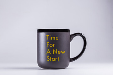 Time for a new Start written on a black cup over grey background