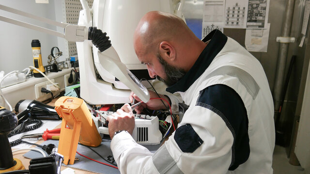 Electrician measurements with multimeter tester - Electronics engineer working on repairing LED Nightclub Moving Head Light 