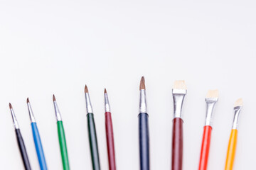 Row of colorful paint brushes. Isolated with copy space