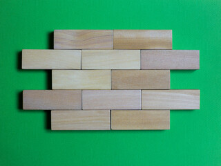natural wood pieces forming a wall. green background with space for text, drawings or graphics. copy for space. consolidated business