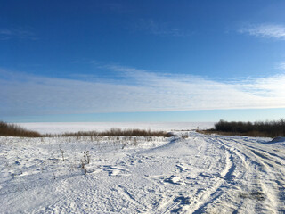 Fototapeta na wymiar Endless winter landscape on a sunny day with blue sky