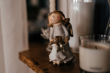 figurine of a white angel with a little daughter on a wooden shelf
