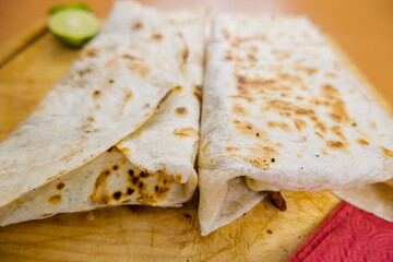 Quesadillas and a slice of lime on a cutting board