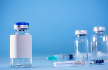 Medical treatment syringes and vaccine bottles in blue environment