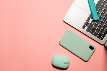 Vivid flat lay photo with a silver grey laptop, light blue computer mouse, turquoise marker, and a...