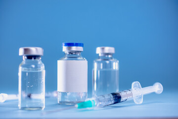 Medical treatment syringes and vaccine bottles in blue environment