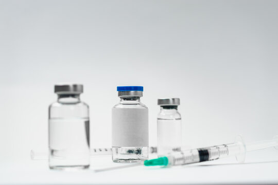 Medical treatment syringes and vaccine bottles in white environment 