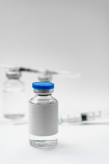 Medical treatment syringes and vaccine bottles in white environment 