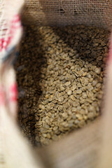 Roasted coffee beans in a burlap sack. High angle view image.
