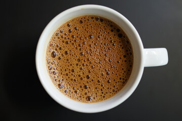 Coffee to go. Milk coffee in a cup on a black wooden table in a cafe.