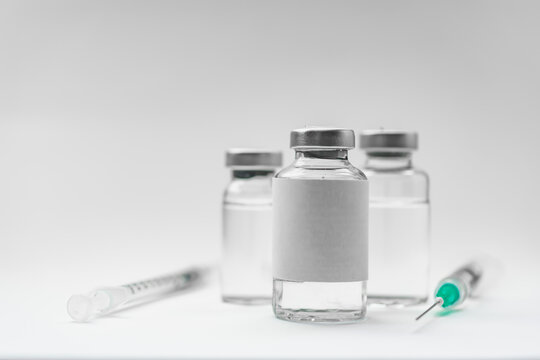 Medical treatment syringes and vaccine bottles in white environment 