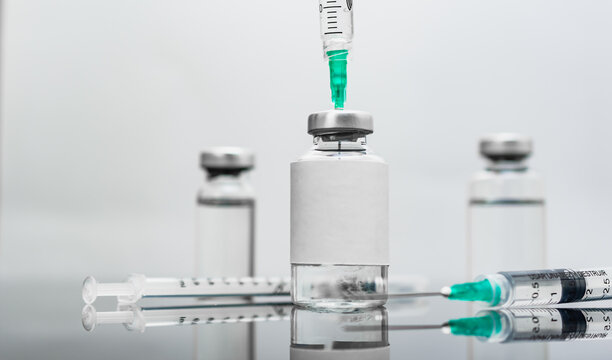 Medical treatment syringes and vaccine bottles in white environment 