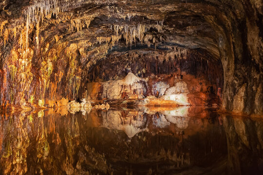 Stalagmites and stalactites reflecting in the water  in the colorful Fairy Grottoes in Saalfeld