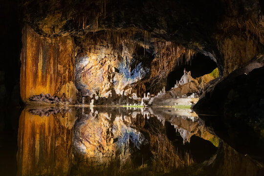 Multi colored speleothems at the end of a dark gallery in the colorful Fairy Grottoes in Saalfeld