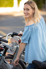 Fototapeta na wymiar attractive girl unlocking rental bicycle