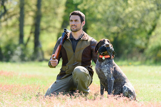 hunter and dog in field