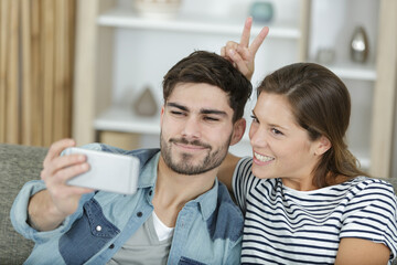 young couple together taking funny photos at home
