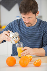 young man make juice with fresh orange