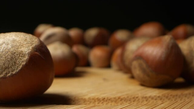 extremely close-up, detailed. background texture food. many hazelnuts on a dark background. changing lighting from dark to light