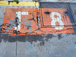 Numbering in red, white and grey on a concrete and metal background at a berth in the harbour
