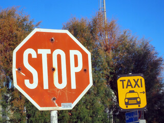 Various signs on the street in red, yellow, black, white and blue