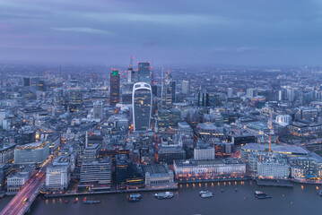 Illuminated London City skyline at dusk blue hour from above