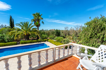 View from the terrace to the luxury pool with clear water in the garden. For tourists.