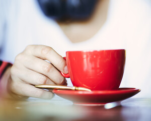 Close up Red Cup of Cappuccino with woman hand