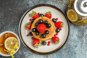 top view yummy pancakes with fruits and tea on a light background sweet fruit breakfast