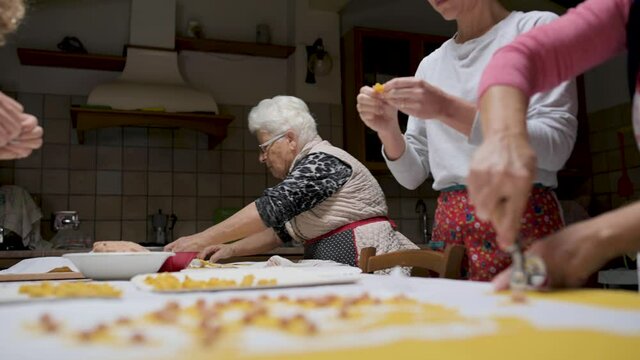 Crop senior woman cooking tortellini at home