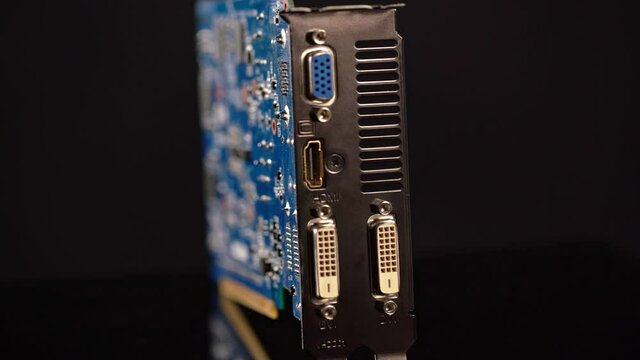 Graphics card for PS platform with two dvi ports, component for video games and cryptocurrency minerization. On a black background in motion.