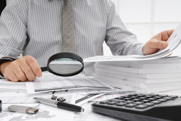 business concept - businessman's working table close view, checks financial reports, writes and counts